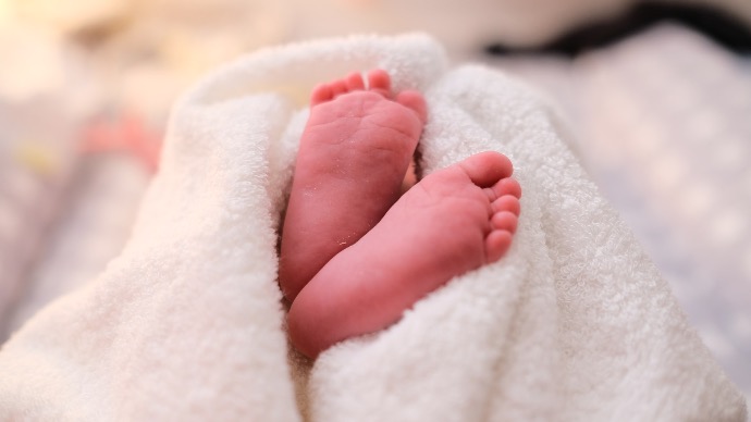 baby covered with white blanket